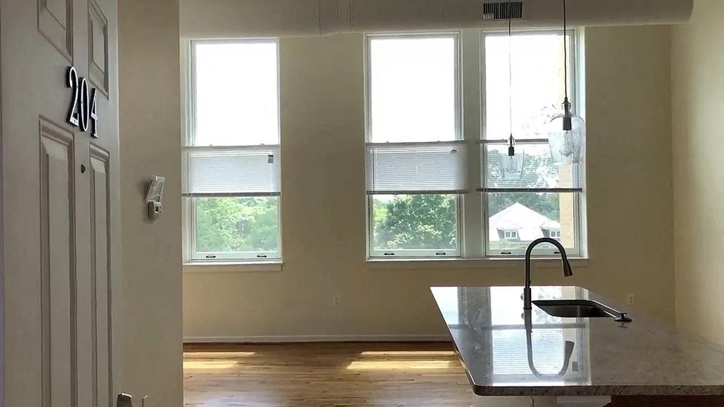 a kitchen with a sink and three windows