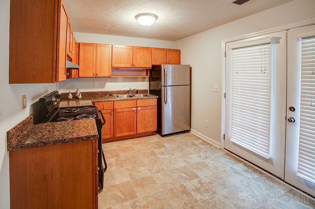 A kitchen with wooden cabinets and a granite countertop.