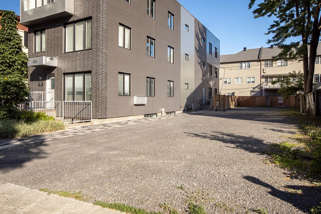 an empty parking lot in front of an apartment building