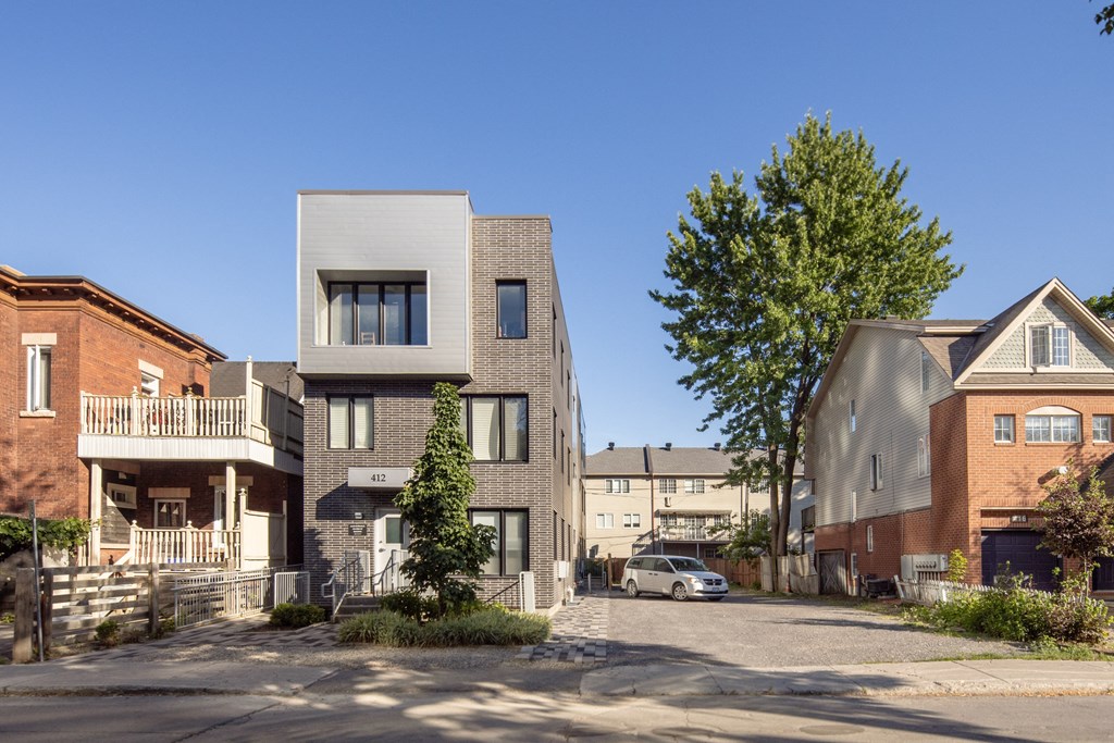a white and brick building with a street in front of it