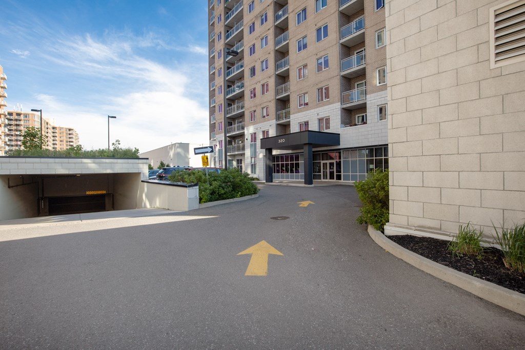 an empty parking lot in front of an apartment building with an arrow painted on it