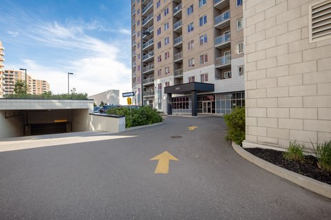 an empty parking lot in front of an apartment building with an arrow painted on it