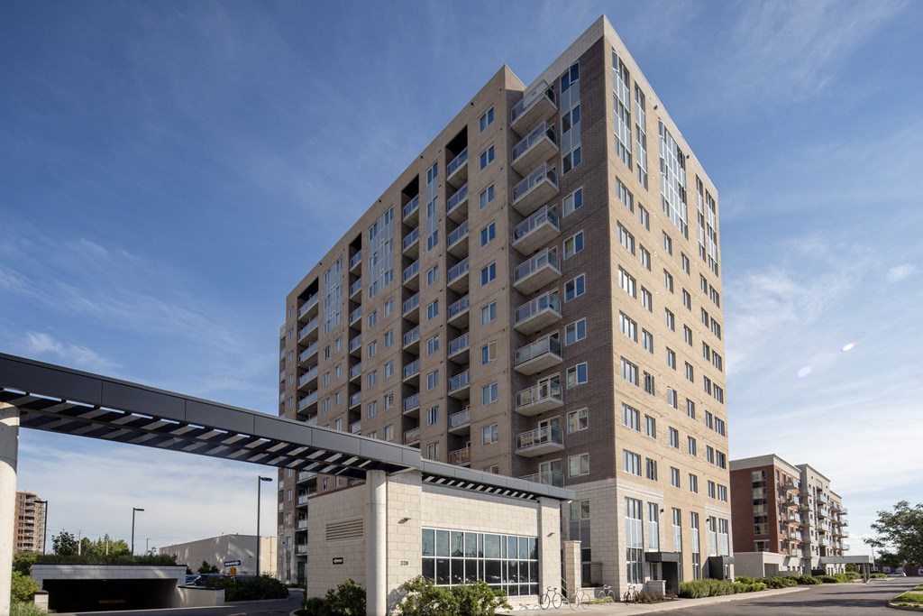 a tall apartment building with a blue sky in the background