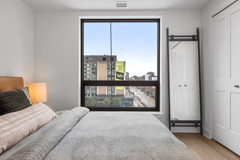 a bedroom with a large window and a bed