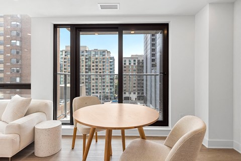 a dining room with a table and chairs in front of a window