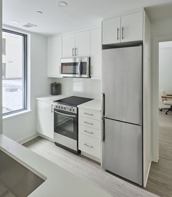 a kitchen with white cabinets and stainless steel appliances