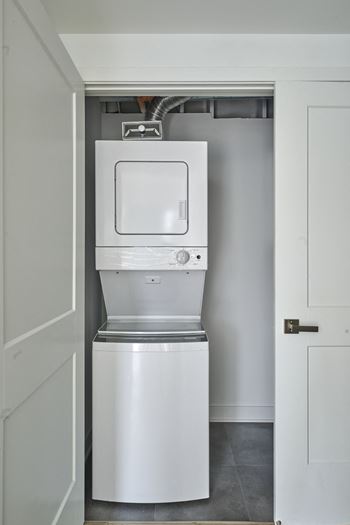 a white washer and dryer in a white closet