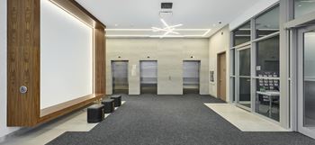a lobby with four elevators and a white screen on the wall