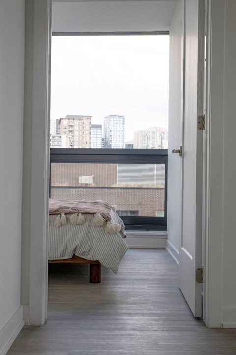 A bedroom with a bed and a view of the city.