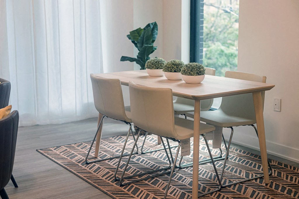 a dining room with a wooden table and white chairs
