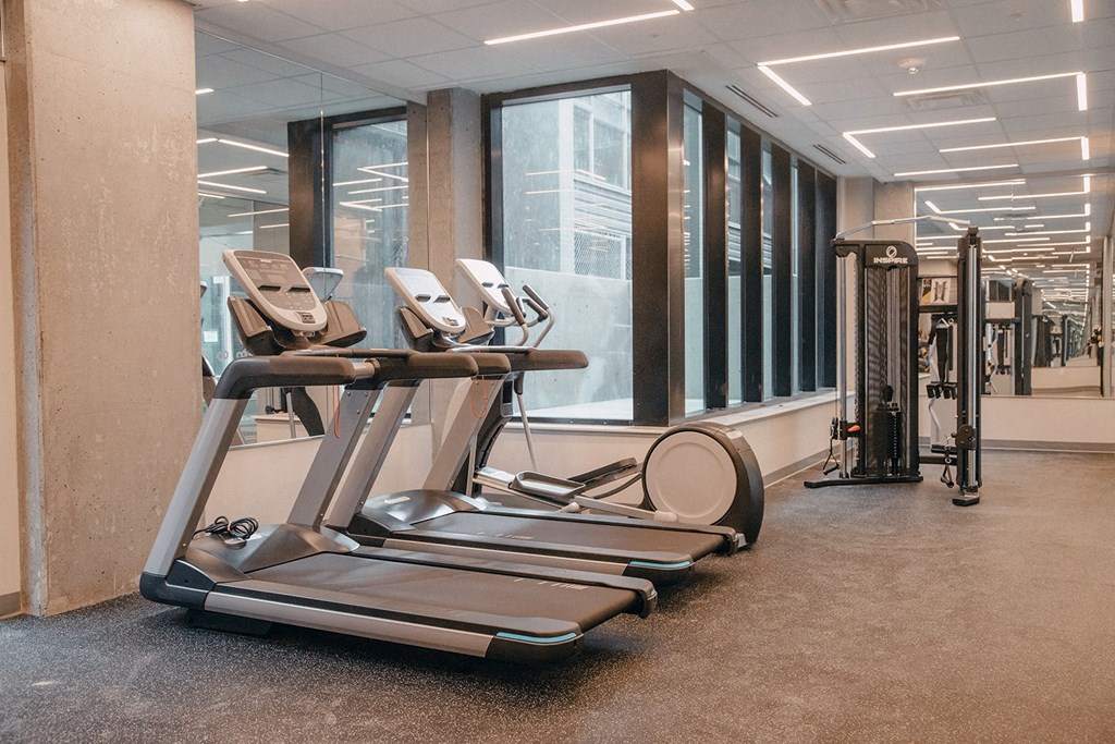 a gym with cardio equipment in the lobby of a building