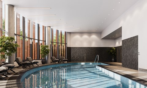A large indoor swimming pool with lounge chairs and a sunken seating area.
