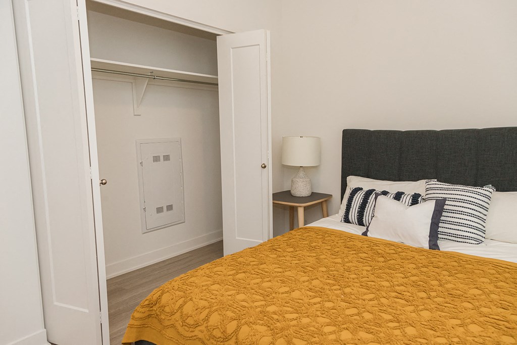 a bedroom with a bed and a door to a closet