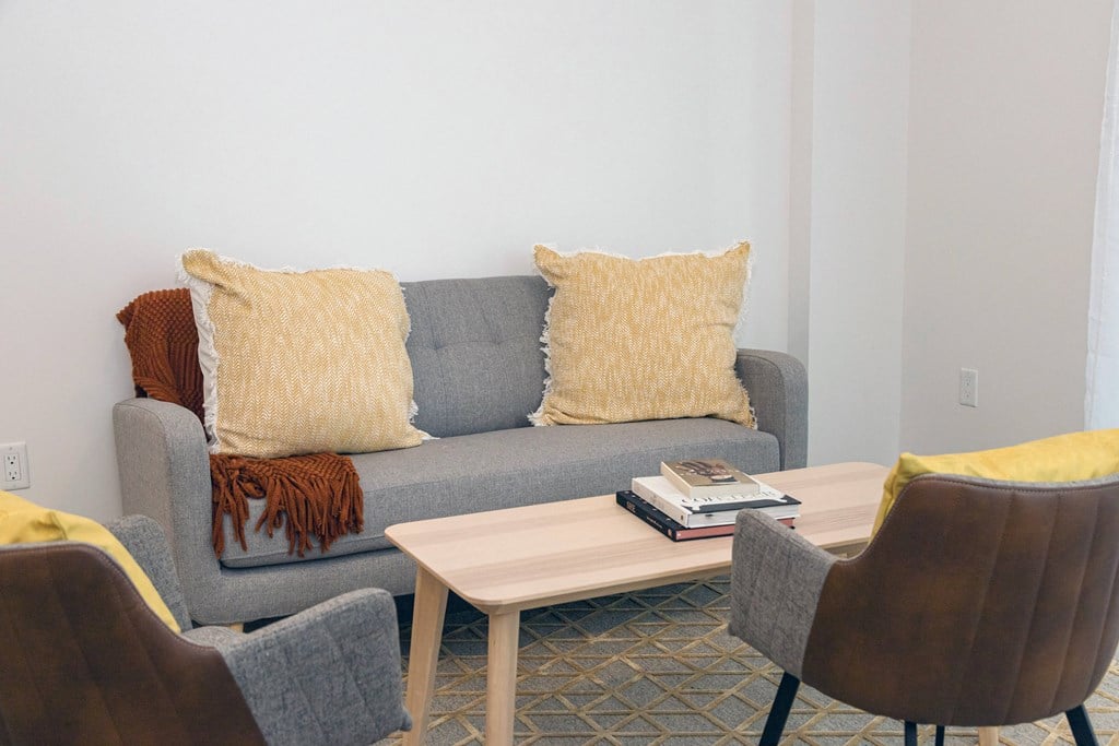 a living room with a couch and chairs and a coffee table
