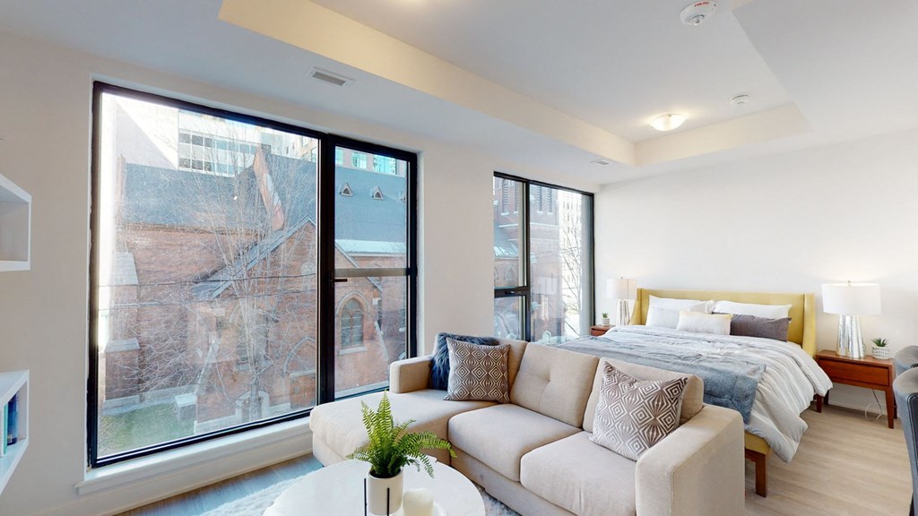 a living room with a bed and a large window