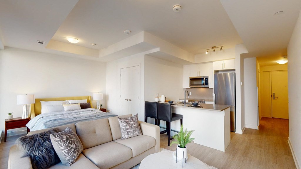 a bedroom with a couch and a bed and a kitchen