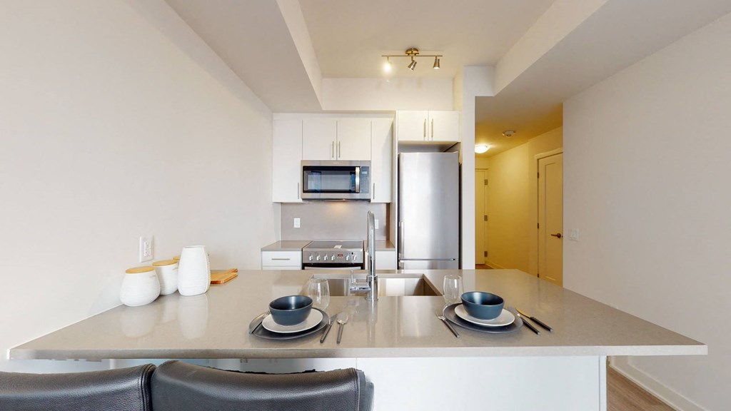 a kitchen with a counter top and a stainless steel refrigerator