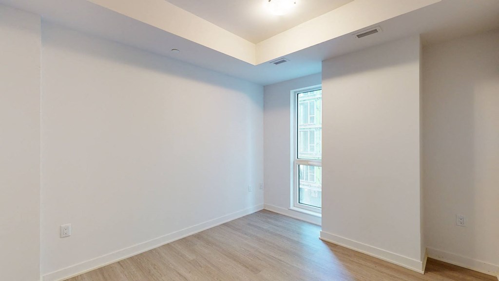 a living room with white walls and a window