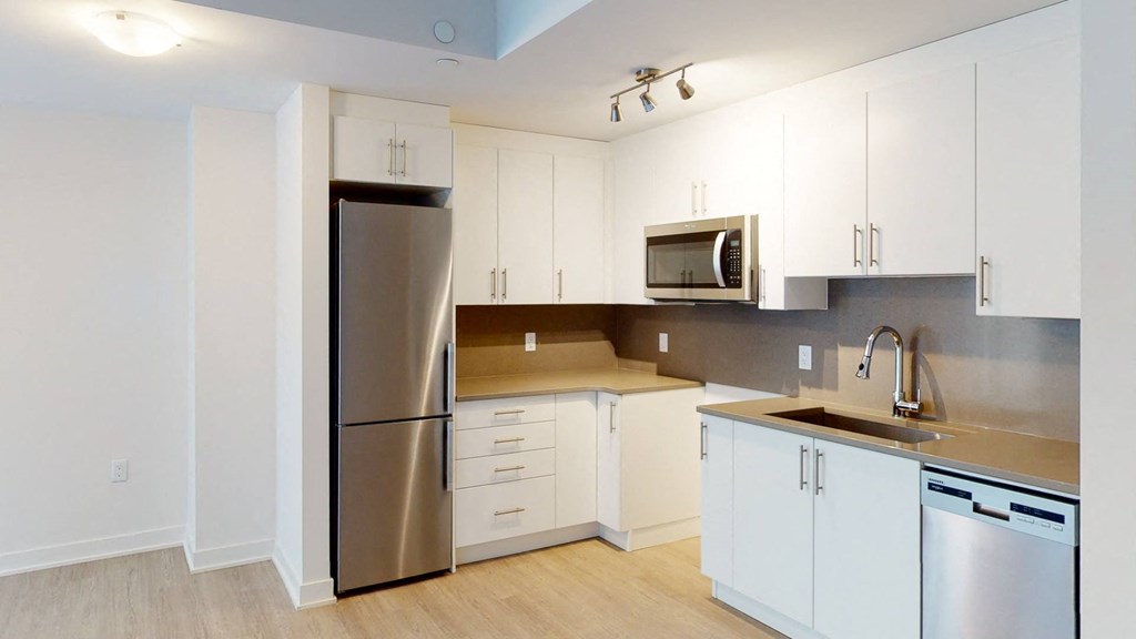 a kitchen with white cabinets and a stainless steel refrigerator