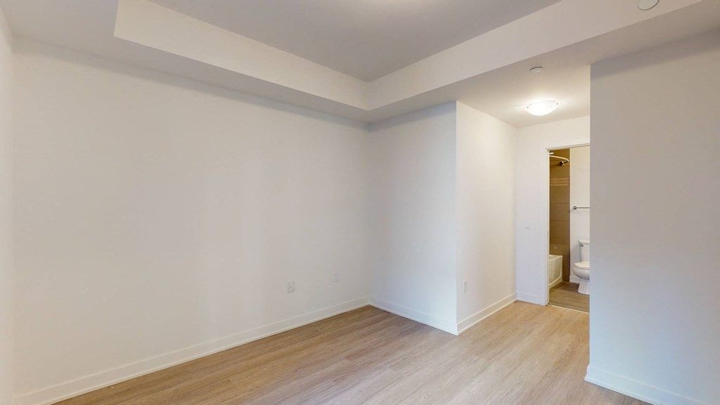 a living room with white walls and wood floors