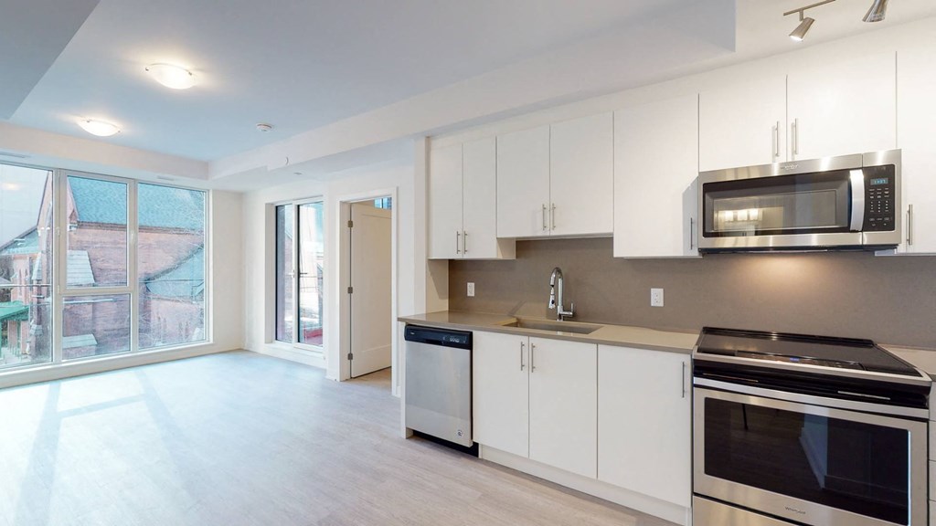a kitchen with white cabinets and a stove and a microwave