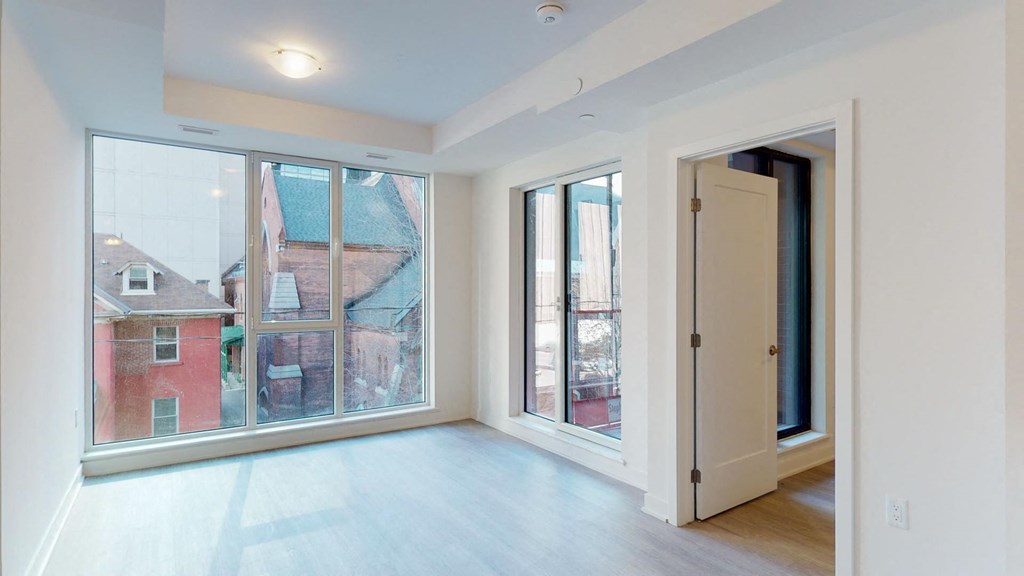 a living room with large windows and a door to a balcony
