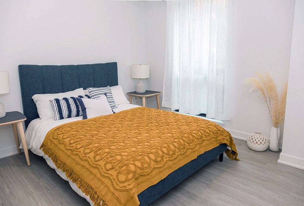 a bedroom with a bed and a yellow blanket