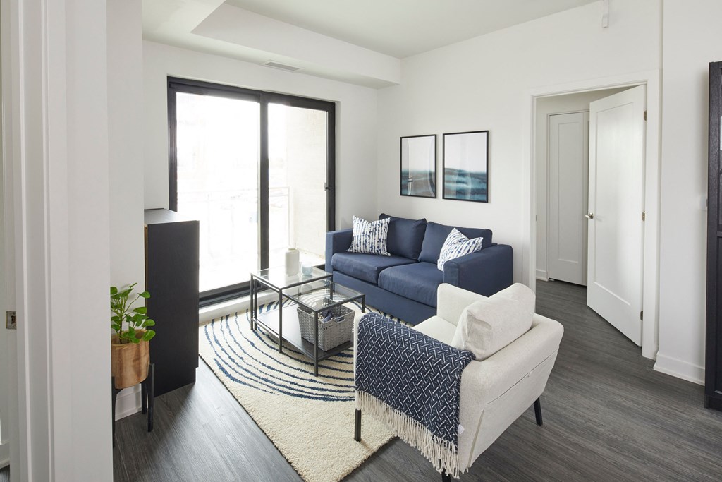 a living room with a blue couch and a glass coffee table