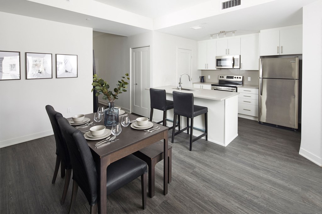 a dining room and kitchen with a table and chairs