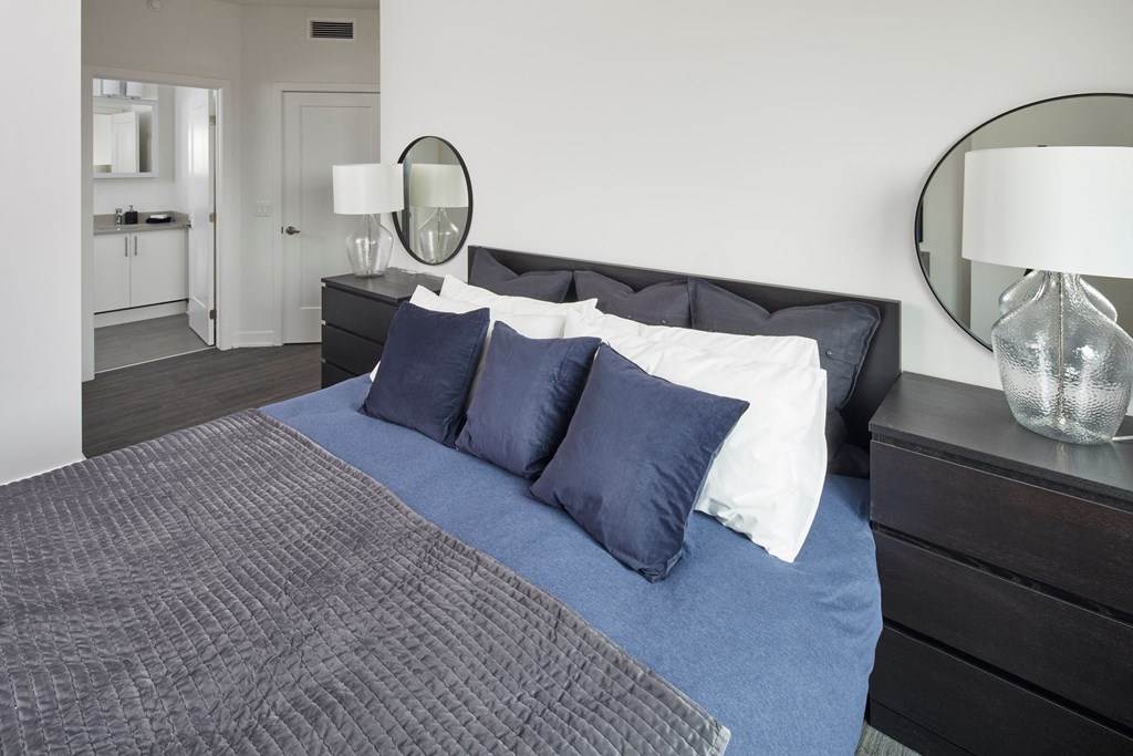 a bedroom with a bed with blue pillows and a blue blanket