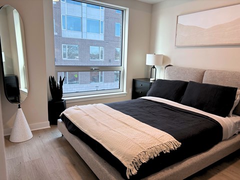 A bedroom with a large bed and a large window.