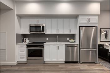 A modern kitchen with stainless steel appliances and white cabinets.