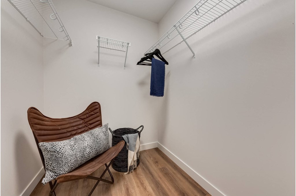 A chair with a pillow and a bag on the floor.