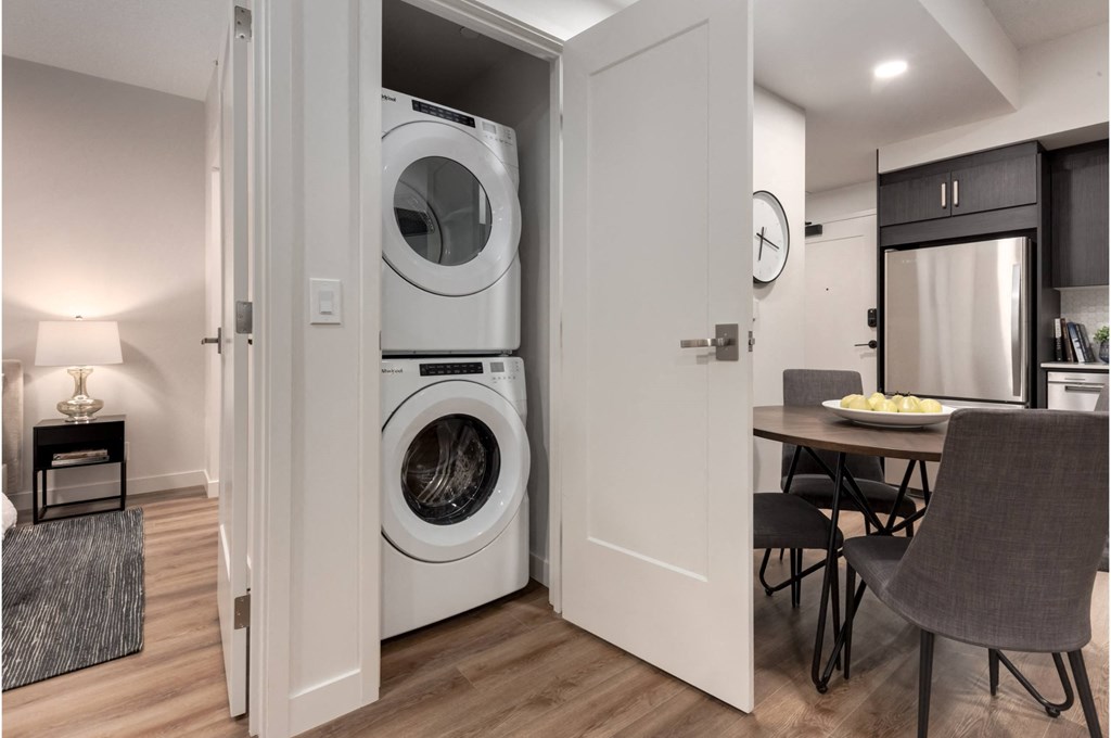 A modern laundry room with a washer and dryer built into the wall.