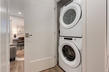 A white washing machine is in a small laundry room.