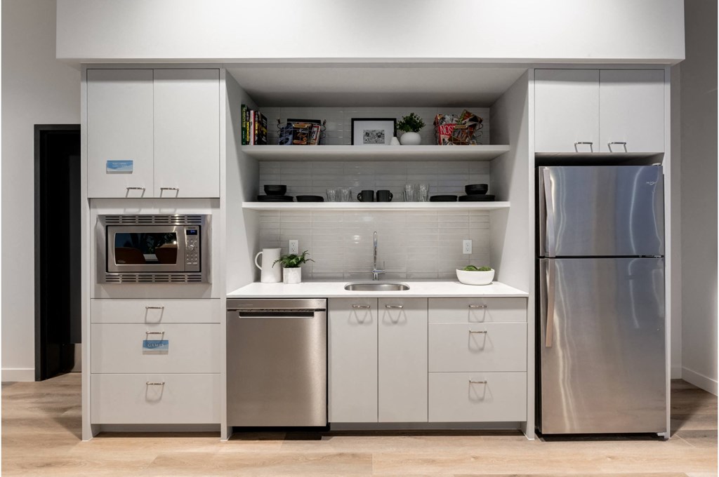 A modern kitchen with a refrigerator, oven, and sink.