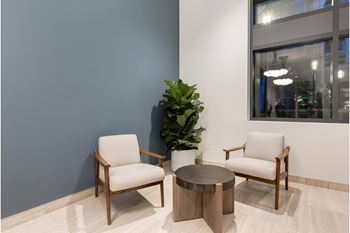 Two chairs and a table are in a room.