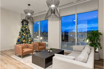 A living room with a Christmas tree and a large window.