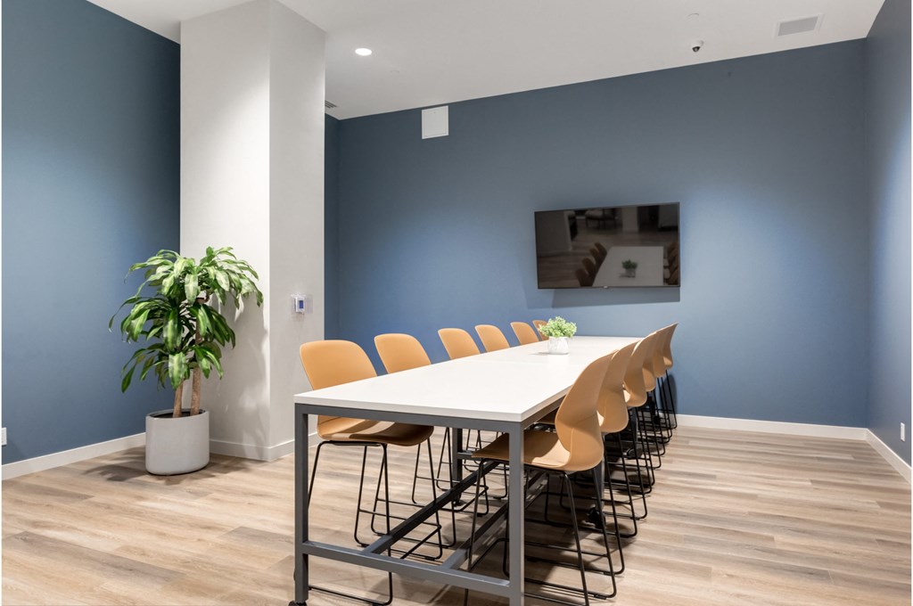 A conference room with a long table and chairs.