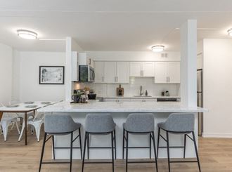 a kitchen with a marble counter top with four stools