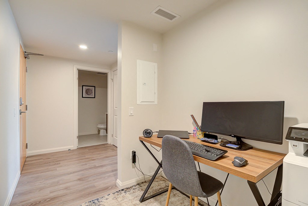 a home office with a computer and a desk with a chair