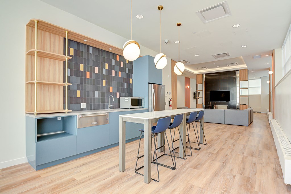 a kitchen with blue cabinets and a long table with chairs