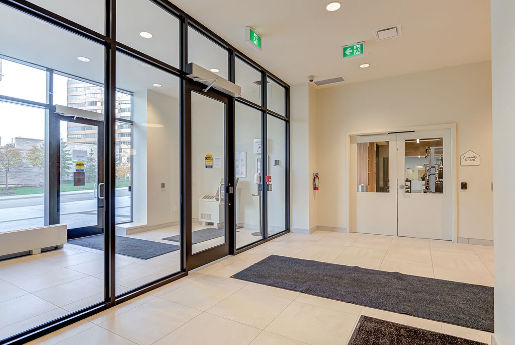 a lobby with glass doors and rugs in a building