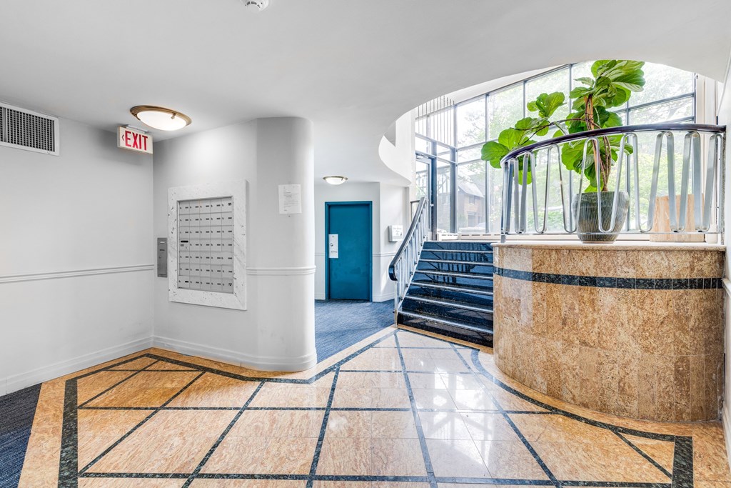 the entrance of a building with a marble reception desk and a blue door