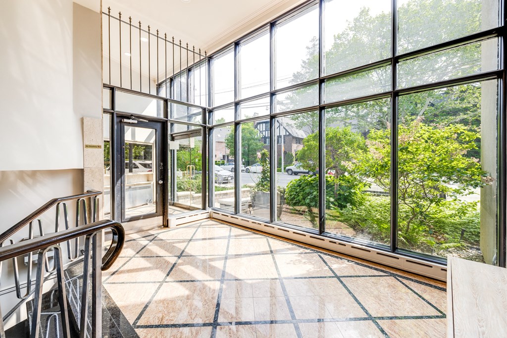 a living room with large glass windows and a staircase