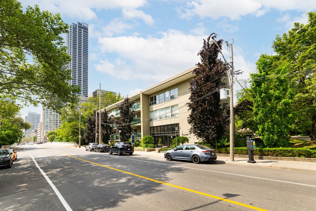 a city street with cars parked in front of a large building