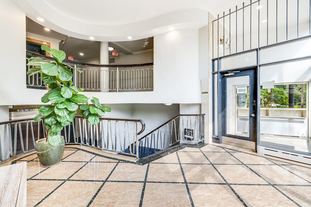 the entrance to a building with a staircase and a plant