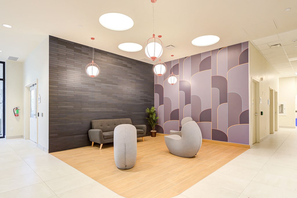 a lobby with chairs and a wall with geometric shapes