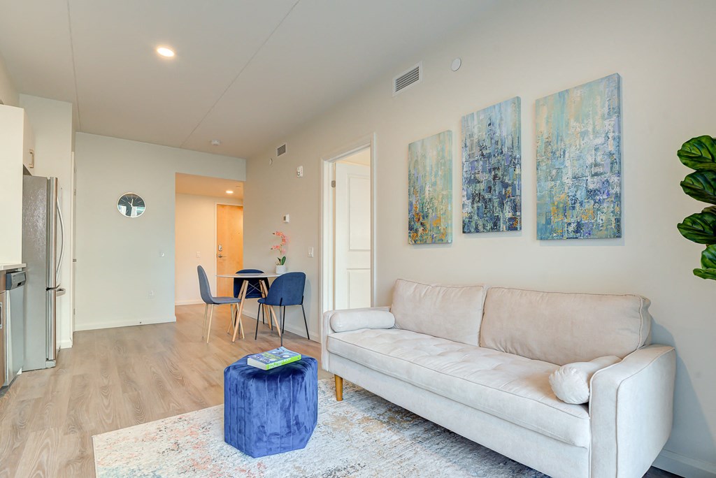 a living room with a couch and paintings on the wall