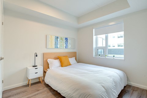 a bedroom with a white bed and a window